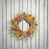 22" wreath made of purple globe amaranthus and Avena oats, along with the sweet zinnia flowers on a white wood fence background. 