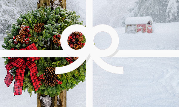 Country Christmas wreath on wooden post in snow