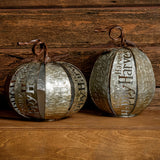 Set of 2 lighted metal pumpkins with a dark wooden background.