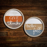 Set of 2 19" round wooden signs saying give thanks and hello fall hung on dark wooden background.
