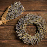 10” dried lavender wreath and an 11” matching bouquet wrapped in kraft paper on a dark wood background.
