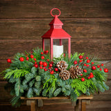 Centerpiece of noble fir, cedar, red berry branches, frosted pine cones, red LED lantern