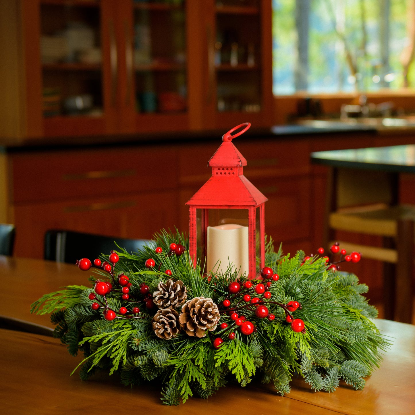 Centerpiece of noble fir, cedar, red berry branches, frosted pine cones, red LED lantern