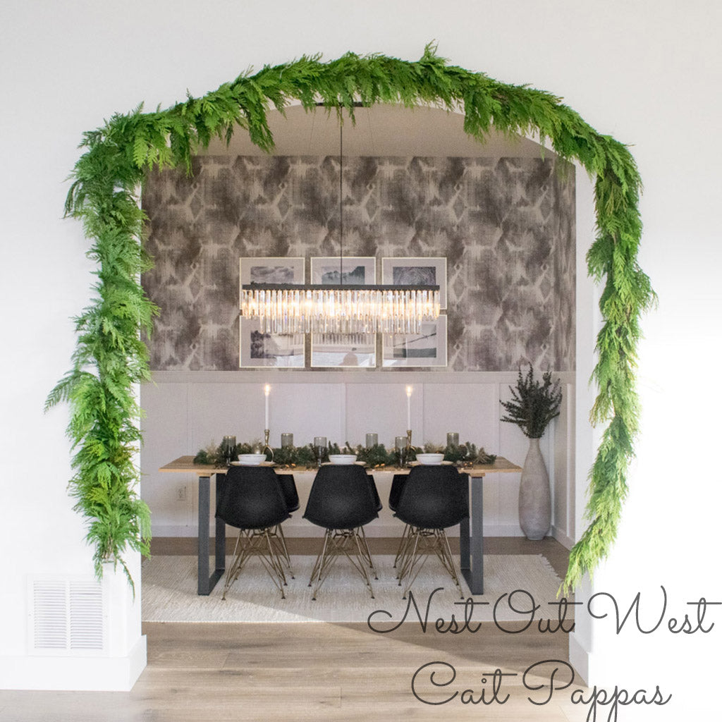 Western red cedar garland hanging over a curved archway to a dining room.