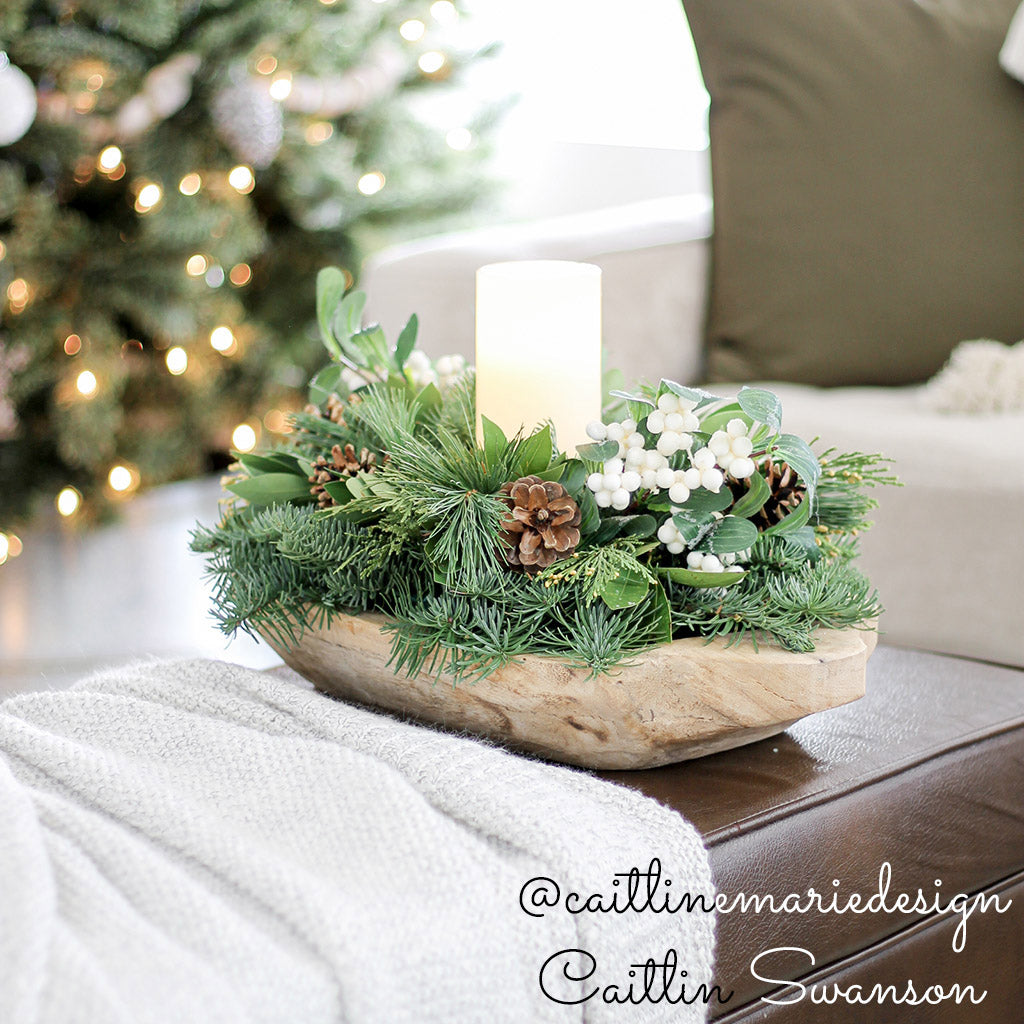 Centerpiece made of noble fir, pine, cedar and bay leaf with white berry clusters, Australian pine cones and 1 white LED pillar candle close up