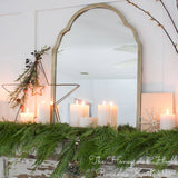 Western red cedar garland draped over a mantle with candles, a mirror, and star decorations. 