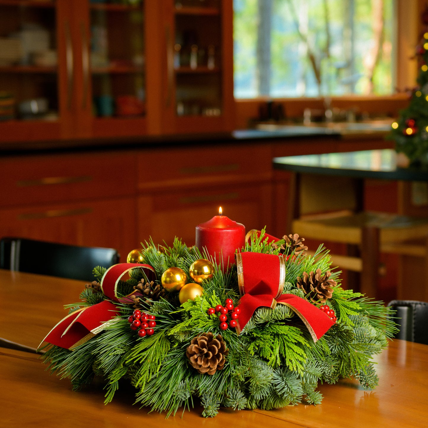 Centerpiece with pine cones, gold balls, red berry clusters,gold trimmed red bow tucks and a red pillar candle