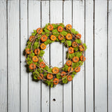 18" natural wreath made of real, dried cherry pumpkins and contrasting green reindeer moss. and grapevine accents on a white wood fence background. 