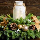 Centerpiece made of noble fir, incense cedar, and white pine with Australian pine cones, gold and silver ball clusters, silver berry clusters, and a lighted holiday glass jar close up