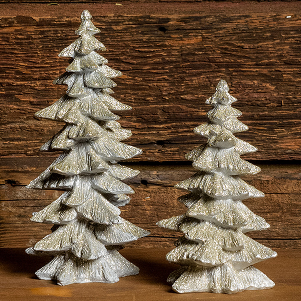 Set of 2 silver glitter trees with a dark wood background.