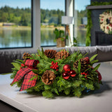 Holiday centerpiece with pine cones, red balls and red and black tartan bows sitting on a kitchen counter