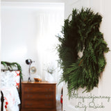 Christmas wreath with cedar and pine hanging on an interior door.